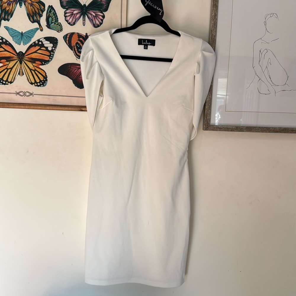 White dress with deep v and fun should cap sleeve into cape style